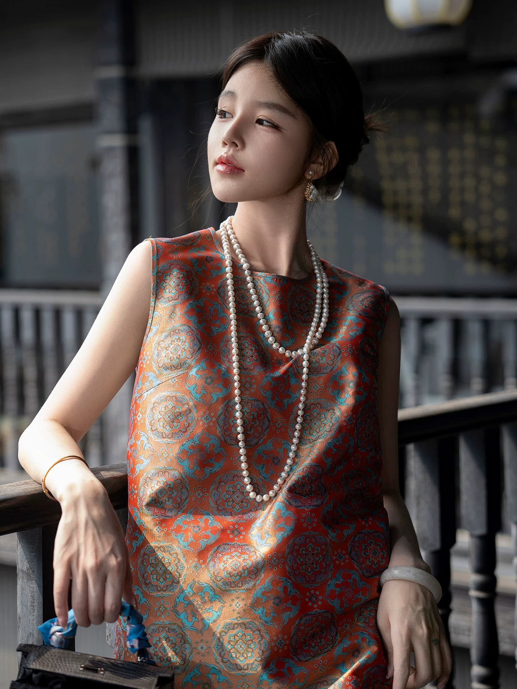 Close model view showing the turquoise and antique-gold medallion pattern of the Shu brocade dress.