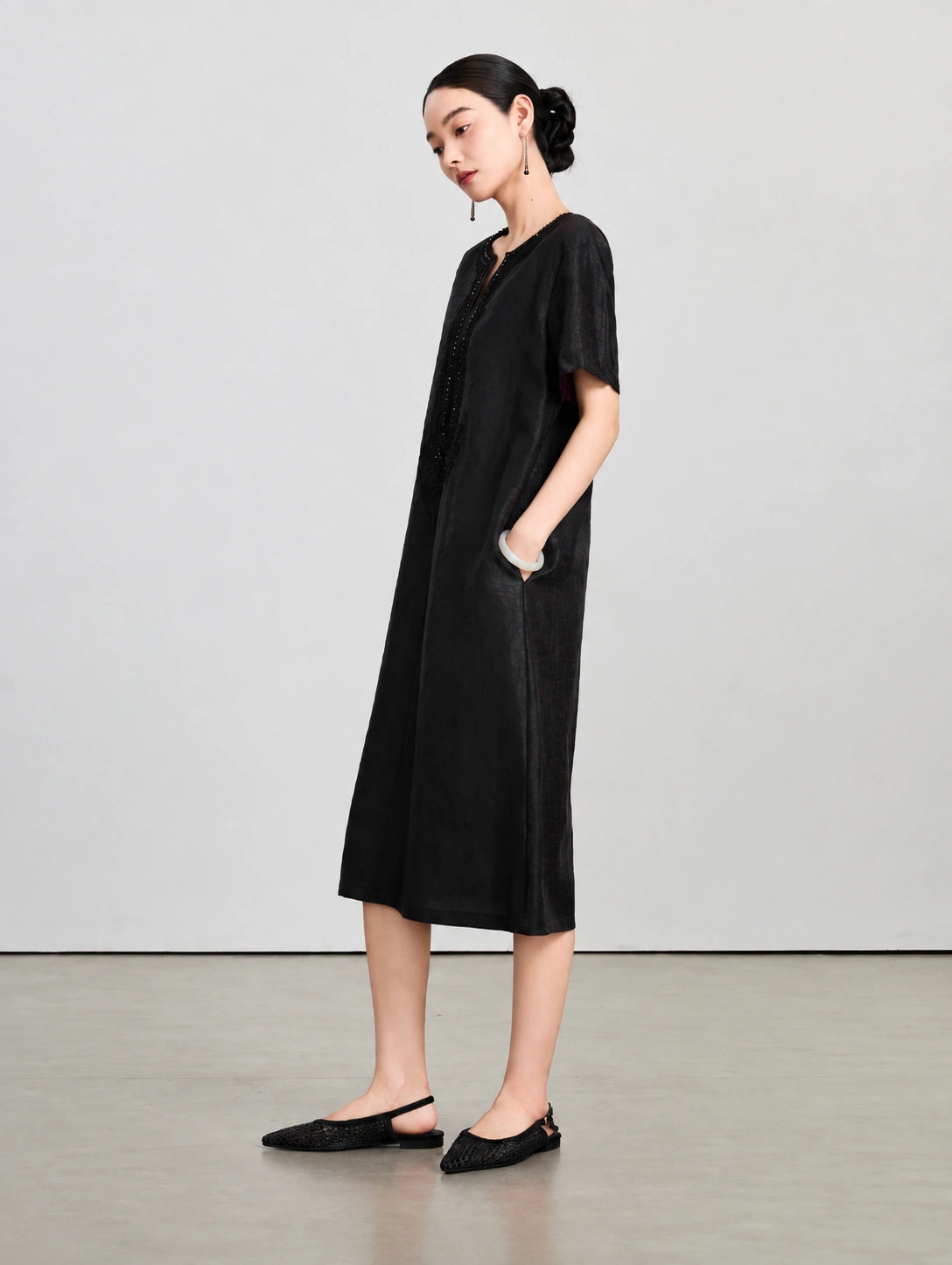 Side view of the relaxed Xiangyunsha silk midi dress showing its short sleeves and side pocket