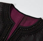 Close-up of the black braided embroidery, faceted beads and purple interior at the V-neckline