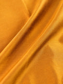 Draped Gilded Ochre silk fabric showing its texture and sheen