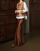 Gilded Ochre embroidered silk vest layered over a white blouse with a brown skirt