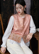Seated model showing the vest’s front closures and embroidered hem