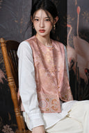 Seated model wearing the peach jacquard vest over a white blouse