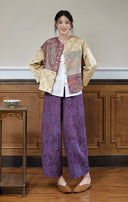 Front view of a model styling the plum and apricot jacket with a white shirt and purple trousers.