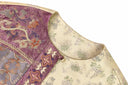Close-up of the jacket’s round neckline, plum patterned panel and apricot-gold fabric.