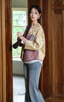 Side view of a model holding a handbag while wearing the patchwork jacquard jacket.