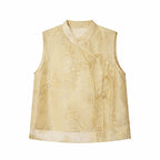 Flat lay of a gold sleeveless embroidered vest with a mandarin collar, floral embroidery, and side tie details.
