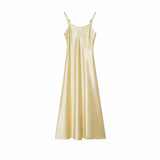 Flat lay of a champagne gold satin slip dress with metallic strap details and a lustrous finish, 100% polyester material.