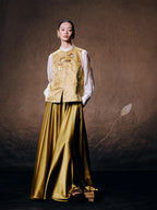 Women's floral embroidered silk blend vest paired with a flowing satin skirt for an elegant oriental-inspired outfit.