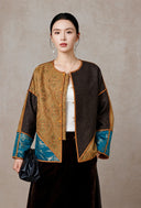 Front view of the model wearing the gold, brown and teal colorblock jacket