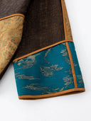 Close-up of the teal patterned cuff, gold jacquard and brown piping