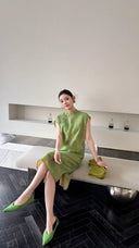 Sitting woman in a green Cheongsam midi dress with a relaxed fit, holding a lime green handbag, perfect for summer outings.