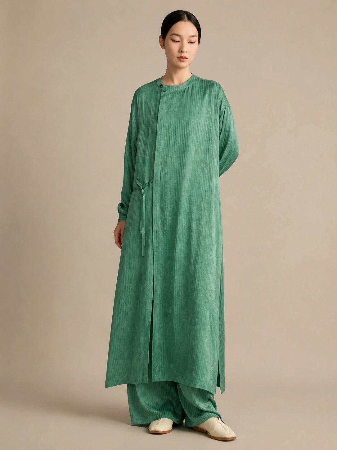 Another front view of the green silk tunic featuring a side tie for adjustable fit and a beautifully textured crinkled silk finish.