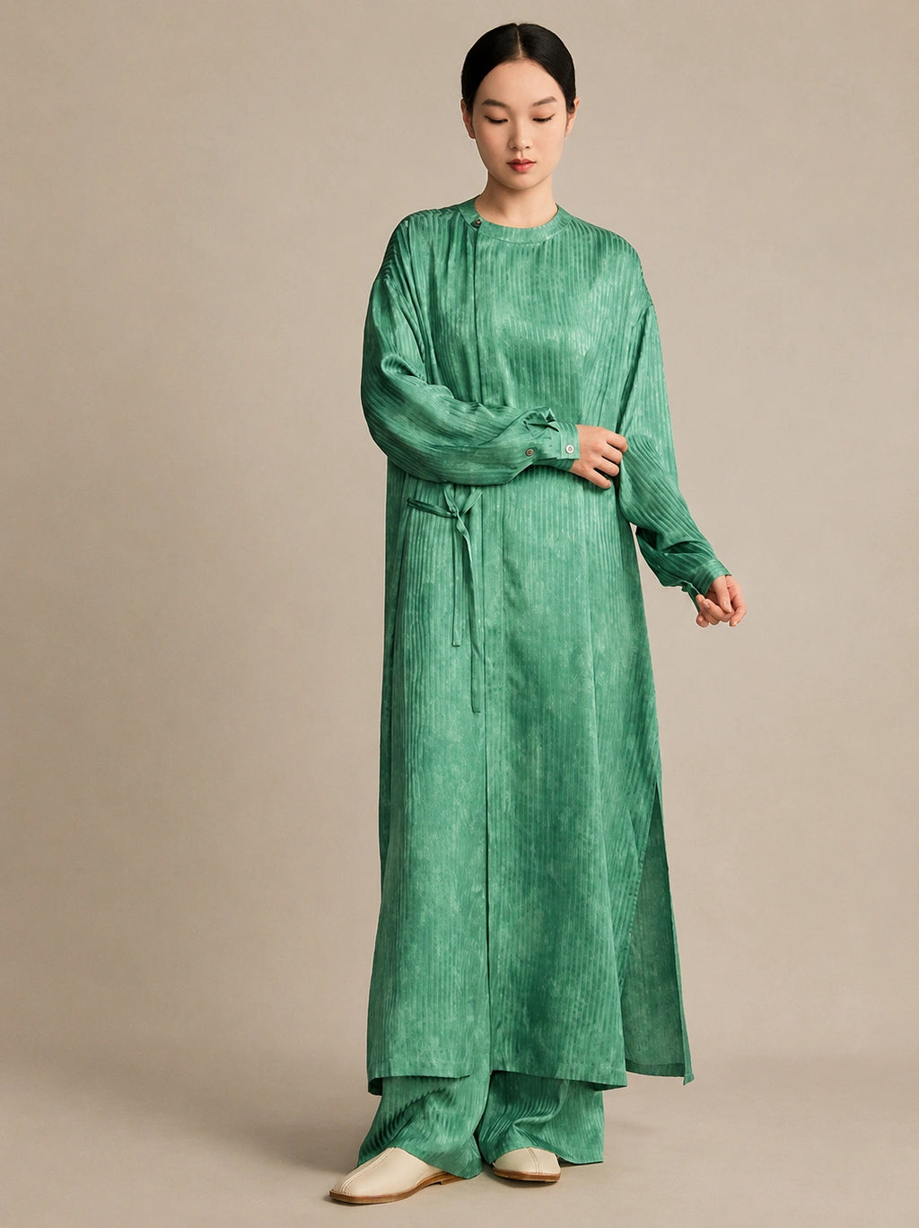 Model wearing a light green 100% mulberry silk crinkled tunic, showcasing the relaxed, comfortable silhouette and natural drape from the front.