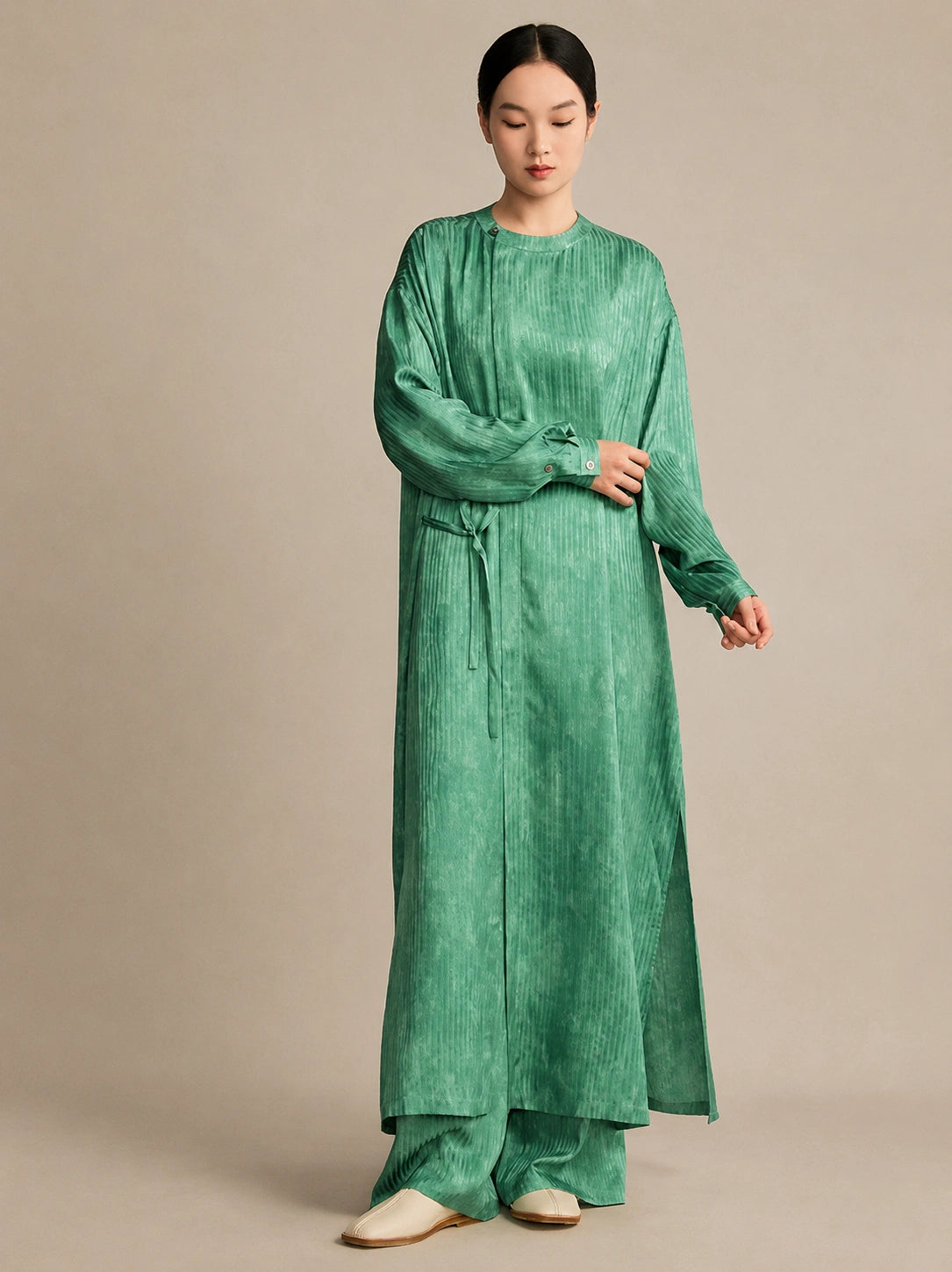 Model wearing a light green 100% mulberry silk crinkled tunic, showcasing the relaxed, comfortable silhouette and natural drape from the front.