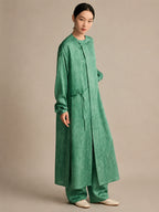 Side view of the green crinkled silk tunic, highlighting the high side slits that provide ease of movement and a fluid, effortless look when paired with matching pants.