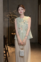 Model wearing a green sleeveless Cheongsam-style vest with floral embroidery and a Peter Pan collar, styled with white wide-leg trousers and a pearl bag.