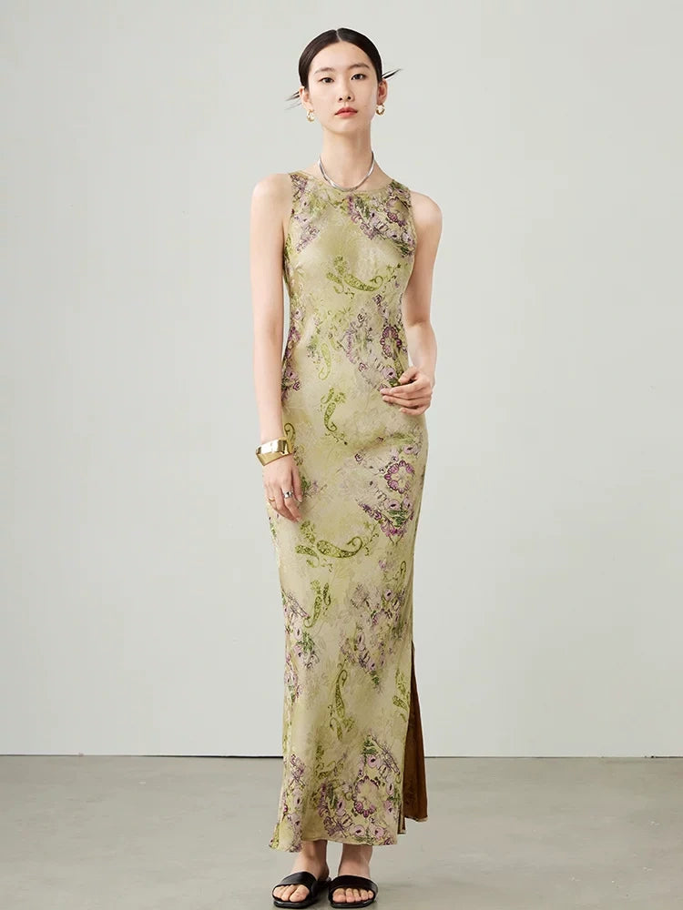 Model walking in a green floral sleeveless maxi dress with a flowing silhouette.