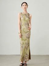 Model walking in a green floral sleeveless maxi dress with a flowing silhouette.