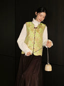 Green floral silk vest styled with a high-neck white blouse and dark skirt