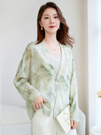 Model wearing a light green 100% mulberry silk V-neck open-front shirt, holding a book, styled with a camisole and white trousers, perfect for a refined New Chinese look.