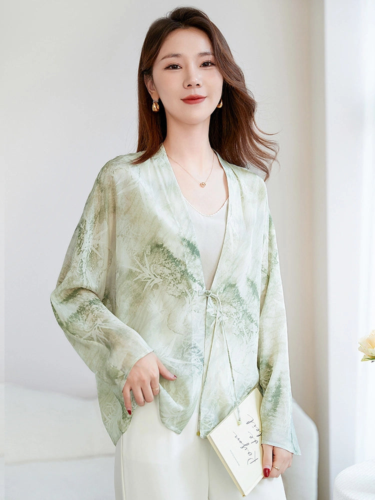 Model wearing a light green 100% mulberry silk V-neck open-front shirt, holding a book, styled with a camisole and white trousers, perfect for a refined New Chinese look.