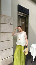 Model in light green wide-leg pants and a translucent white top, highlighting the comfortable fit and the elegant drape of the 75% viscose blend fabric.