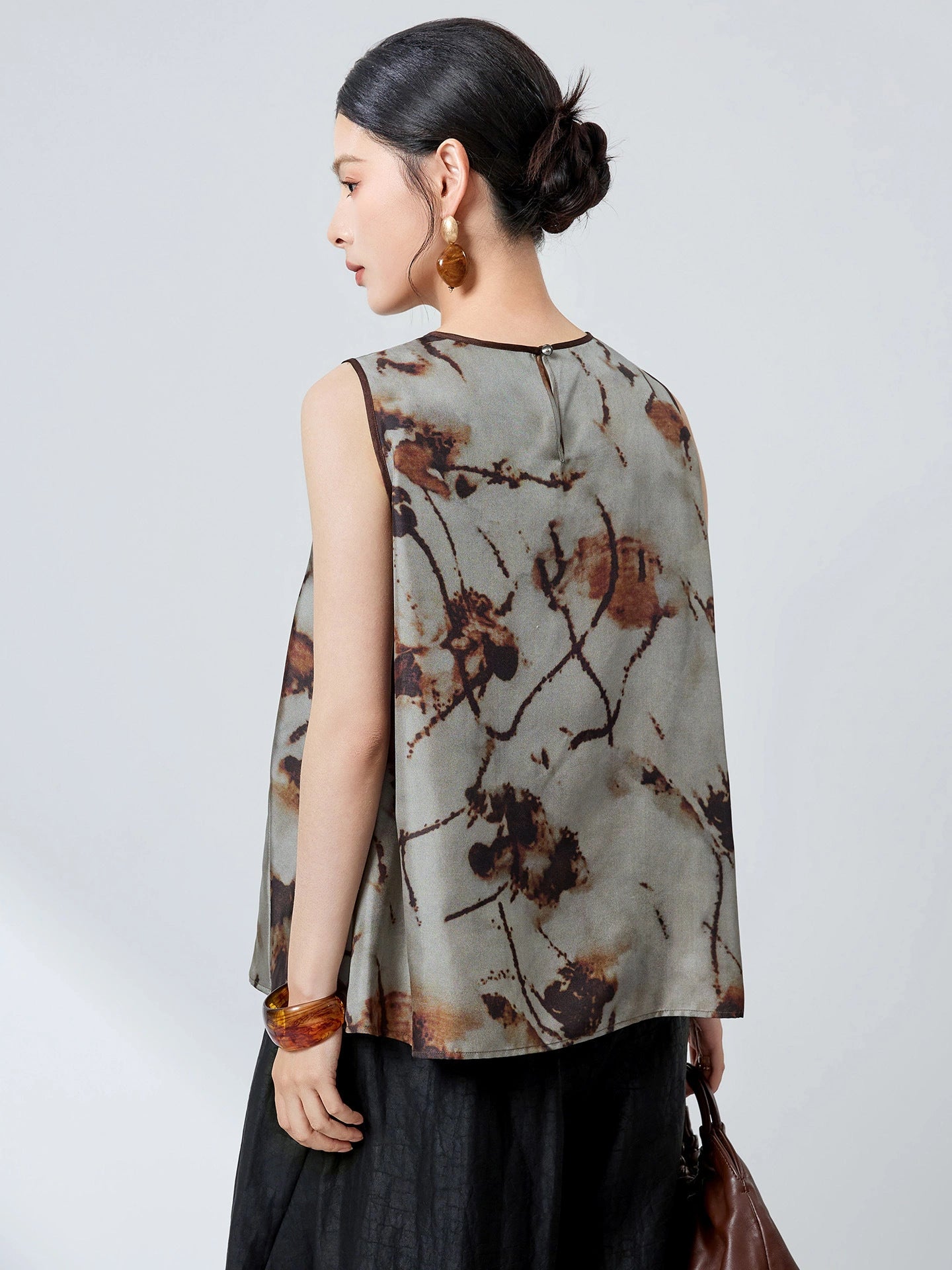 Back view of a grey 100% mulberry silk tank top with an abstract ink wash floral print and a back zipper closure.