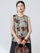 Front view of a grey 100% mulberry silk tank top with a round neckline and brown trim, featuring a relaxed fit and abstract ink wash print.