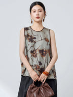 Front view of a grey 100% mulberry silk tank top with a round neckline and brown trim, featuring a relaxed fit and abstract ink wash print.