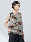 Side view of a grey 100% mulberry silk tank top with a relaxed A-line silhouette and burnt-umber ink pattern, paired with black textured pants.