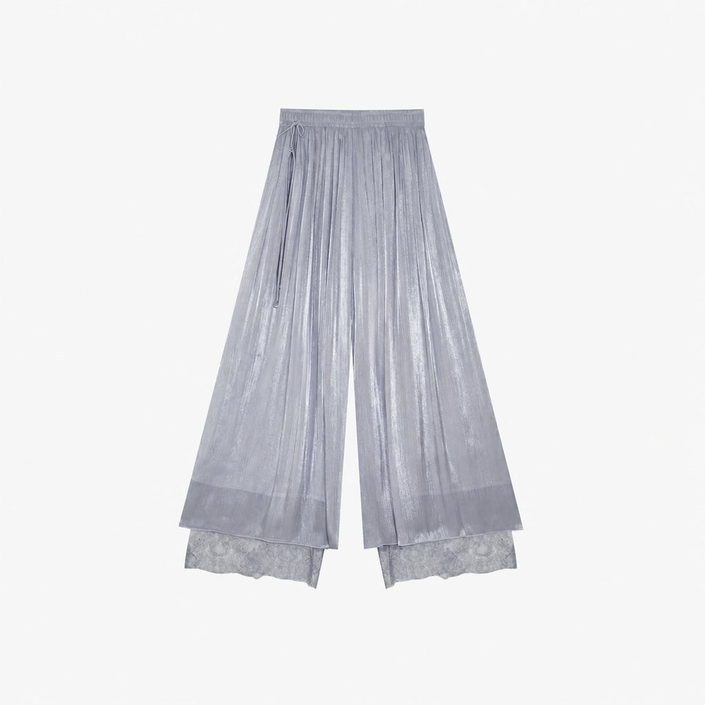 Flat lay of grey pleated wide-leg pants with an elastic waistband, side tie, and layered lace hem, crafted from 100% polyester.