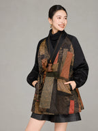 Close-up of the wrap neckline, waist tie and mixed geometric motifs on the Gambiered Silk down coat.