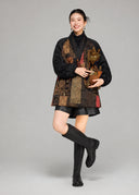 Full-length styling view of the loose black silk goose down coat with patterned front panels and balloon sleeves.