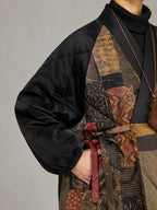 Detail view of the black quilted sleeve, patterned silk panels and adjustable waist tie.
