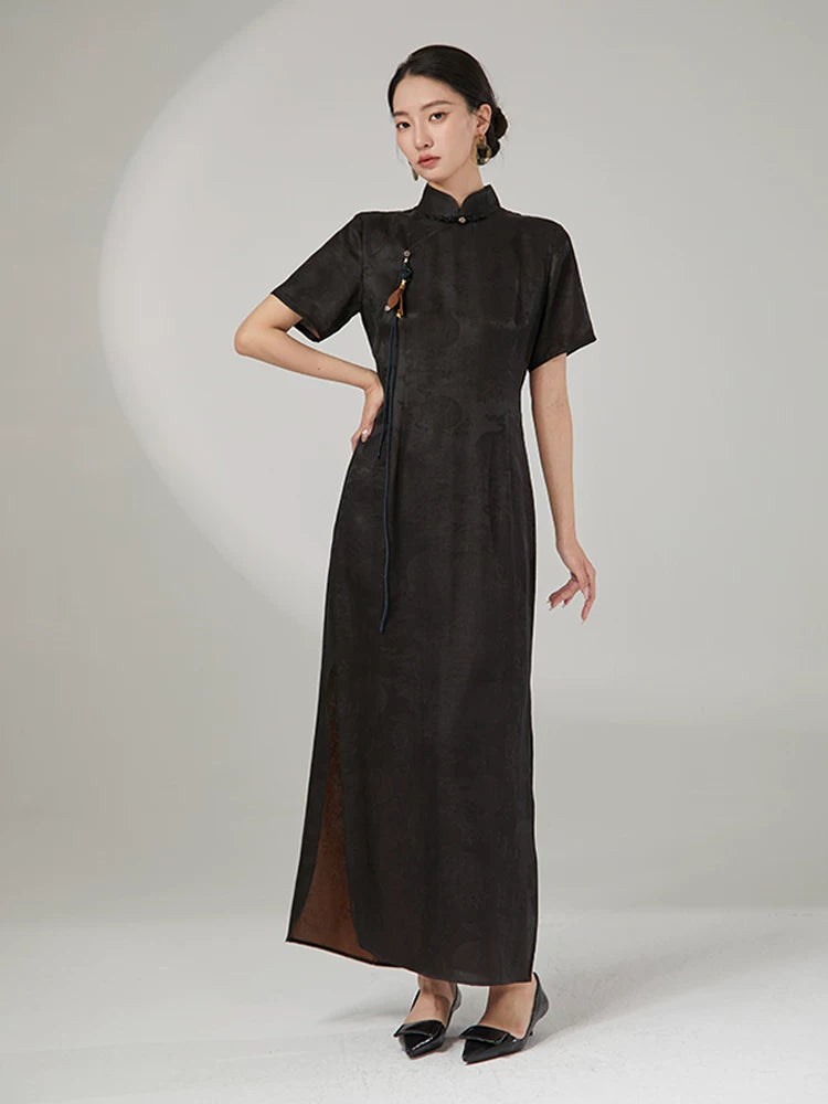 Elegant woman wearing an ink black 100% mulberry silk jacquard cheongsam maxi dress with a mandarin collar.