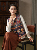 Model seated in the Inkstone Blue embroidered vest with one hand near her chin