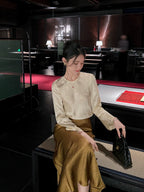 Ivory floral jacquard acetate blouse styled for evening wear with a relaxed feminine silhouette.