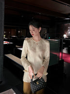 Front view of a woman wearing an ivory acetate jacquard blouse styled with a satin bronze skirt.
