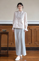 Full-length front view showing the embroidered vest styled with a pale top and long skirt.