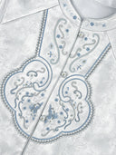 Close-up of the vest’s blue scroll embroidery, floral accents and pearl-tone front buttons.