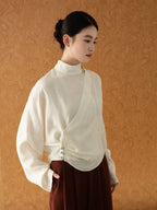 Side view of the Ivory Cross-Over Mandarin Collar Blouse featuring an elegant draped silhouette.