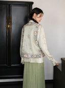 Back view of an ivory floral silk Chinese vest with decorative embroidered panels and a stand collar.