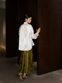Back view of the ivory lotus jacquard acetate Mandarin collar shirt styled with an olive satin skirt