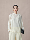 Front view of the ivory long-sleeve lyocell blouse styled with tonal trousers and a black bag