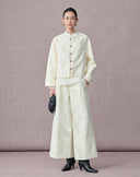 Ivory Mandarin collar blouse layered beneath a tonal jacquard jacket with wide-leg trousers