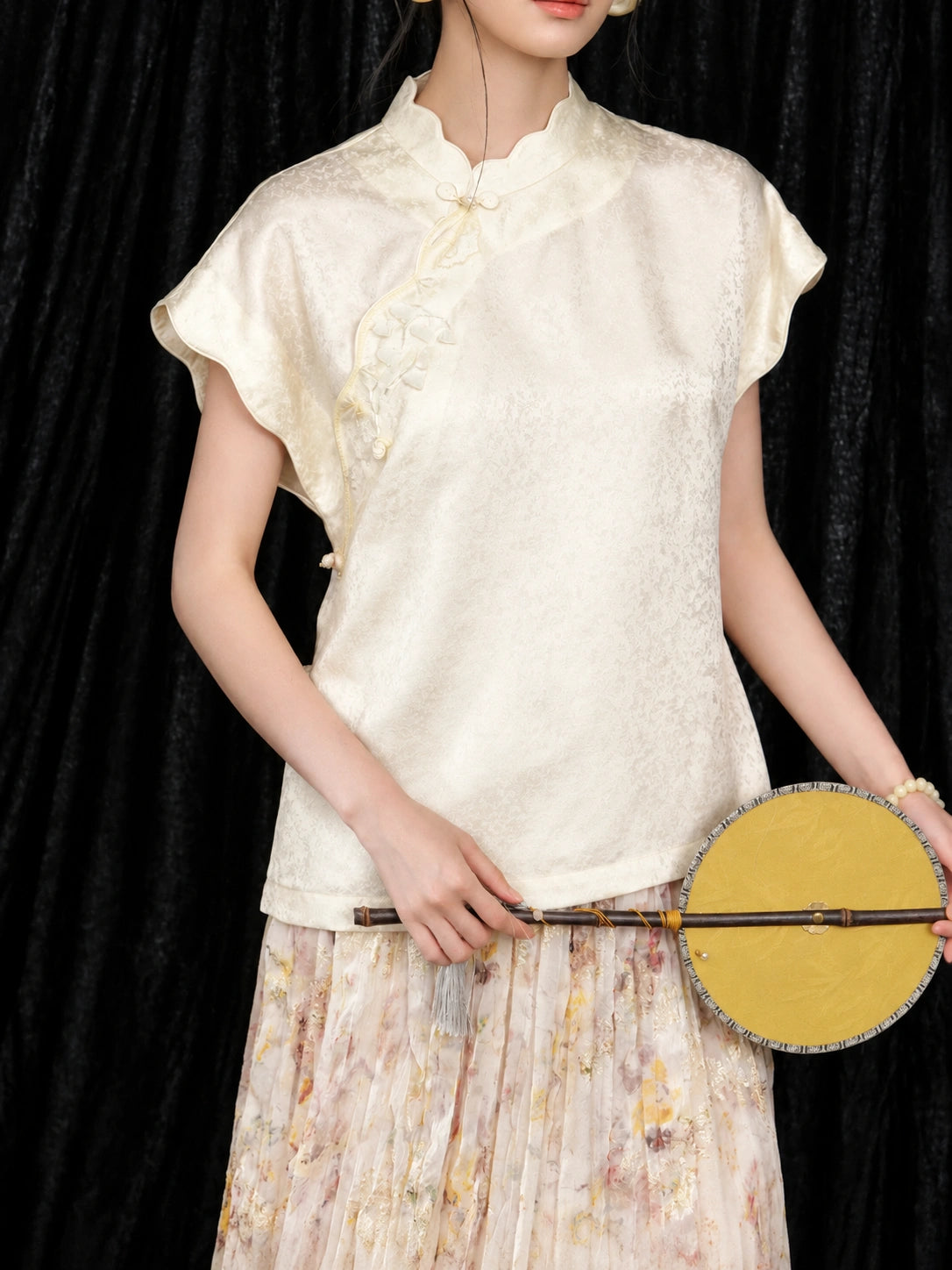 Close-up of the ivory mulberry silk qipao collar top with delicate bead embroidery and jacquard texture