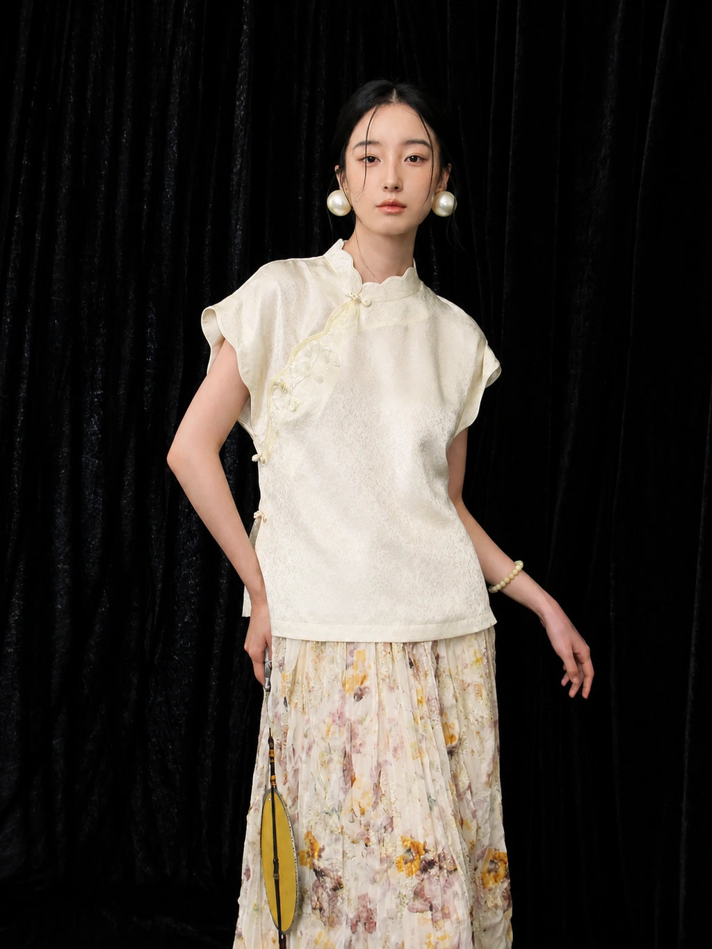 Model wearing an ivory 100% mulberry silk qipao collar top with short sleeves and subtle woven texture