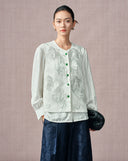 Model wearing the ivory phoenix embroidered acetate vest over a matching blouse