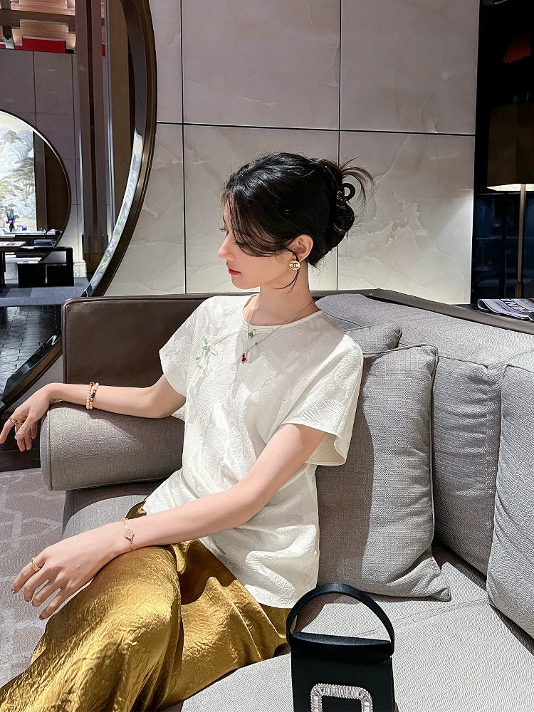 Woman wearing an ivory mulberry silk blend jacquard blouse paired with a satin skirt in a modern interior.